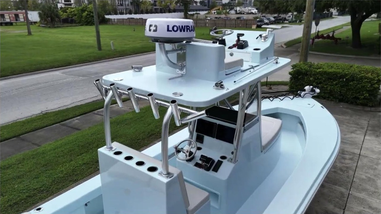Rick's ice blue East Cape 25 Open on the trailer at East Cape — second-station tower, rod holders, Lowrance dome — a frame from the walk-around video